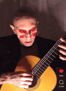 a man wearing red sunglasses is playing a guitar with 185k likes