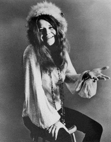a black and white photo of a woman wearing a white fur hat