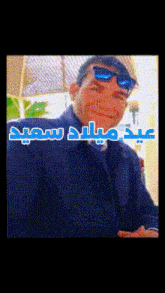 a man wearing sunglasses and a black jacket with arabic writing
