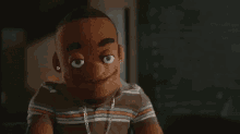 a close up of a puppet wearing a striped shirt and earrings .