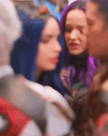 a blurry photo of a group of people including a woman with blue hair