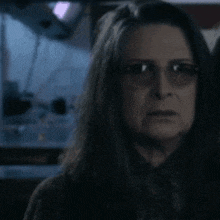 a close up of a woman wearing glasses and a sweater