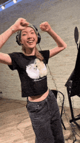 a woman wearing headphones and a black t-shirt with a picture of a cat on it