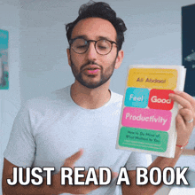 a man is holding a book that says feel good productivity
