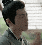 a close up of a man with his eyes closed
