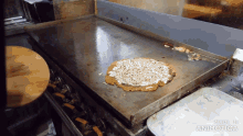 a pizza being cooked on a griddle with the words made in animatica on the bottom right