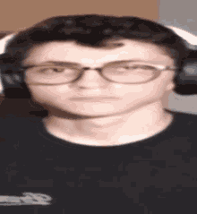 a young man wearing glasses and headphones is making a face .