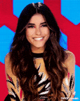 a woman with long brown hair is smiling for the camera