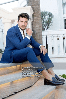 a man in a blue suit is sitting on a set of stairs