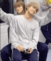 two men are sitting next to each other on a chair .