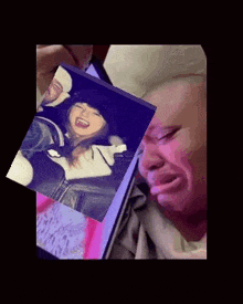 a man is crying while looking at a picture of a girl .