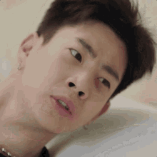 a close up of a young man 's face with his eyes closed and his nose visible .