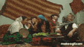 a group of people are sitting around a table eating and laughing .