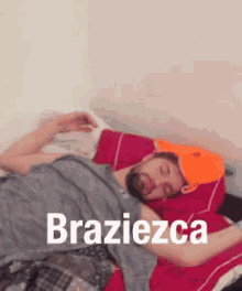 a man is sleeping on a bed with the word braziezca on the bottom of the image .