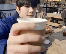 a man holding a cup of coffee in his hand