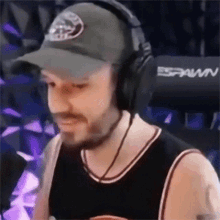 a man wearing headphones and a hat with the word spawn on it