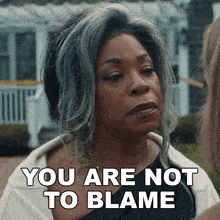 a woman says " you are not to blame " in front of a white house