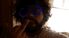 a man with a beard is wearing glow in the dark glasses