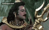 a man dressed as a deity is holding a trident in his hand .