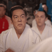 a man in a white karate uniform looks at something