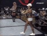 a woman in a bikini is walking out of a wrestling ring .