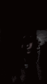 a woman 's face is visible in the dark .