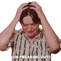 a man in a striped shirt has his hands on his head and the words i 'm freaking out above him