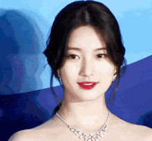 a close up of a woman wearing a necklace and red lipstick