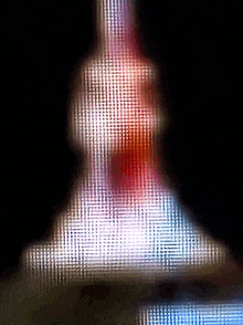 a blurry picture of a red white and blue object with a black background