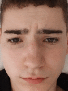a close up of a young man 's face making a funny face .