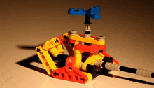 a yellow red and blue lego helicopter with a shadow