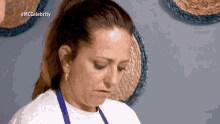 a woman wearing a white shirt and blue apron is on a tv show called mcccelebrity