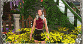 a woman in a red top and black skirt stands in a field of yellow flowers .