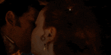 a man and a woman are kissing in the dark