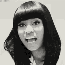 a black and white photo of a woman with her mouth open and bangs .