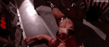 a female wrestler is laying on her back in a ring .