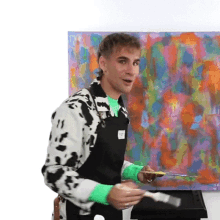 a man wearing an apron is painting a colorful painting