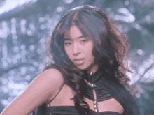 a woman with long dark hair is wearing a black cape