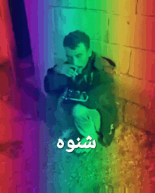a man smoking a cigarette in front of a rainbow colored background with the word shoo on it