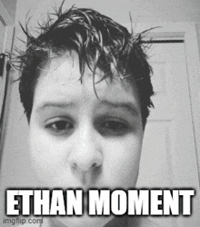 a black and white photo of a young boy with a caption that says " ethan moment "