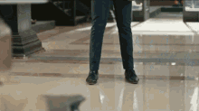 a man in a suit and black shoes is standing on a tile floor