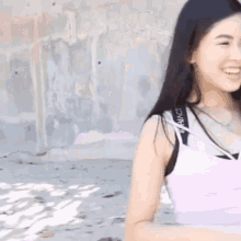 a woman wearing a pink tank top with the word london on the side
