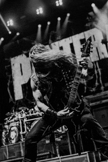 a man with long hair is playing a guitar in front of a sign that says purgatory