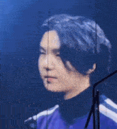 a close up of a person 's face with a microphone in the background .