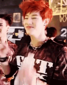 a young man with red hair is wearing a shirt that says ' tt ' on it