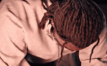 a man with dreadlocks is wearing a white sweatshirt