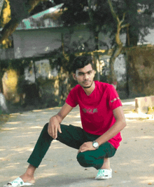 a young man wearing a red shirt with the word hope on it sits on the ground