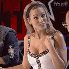 a woman is sitting in front of a sign that says " got talent "