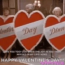 a group of women are holding valentine 's day hearts in a row .