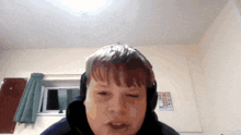 a boy wearing headphones looks at the camera